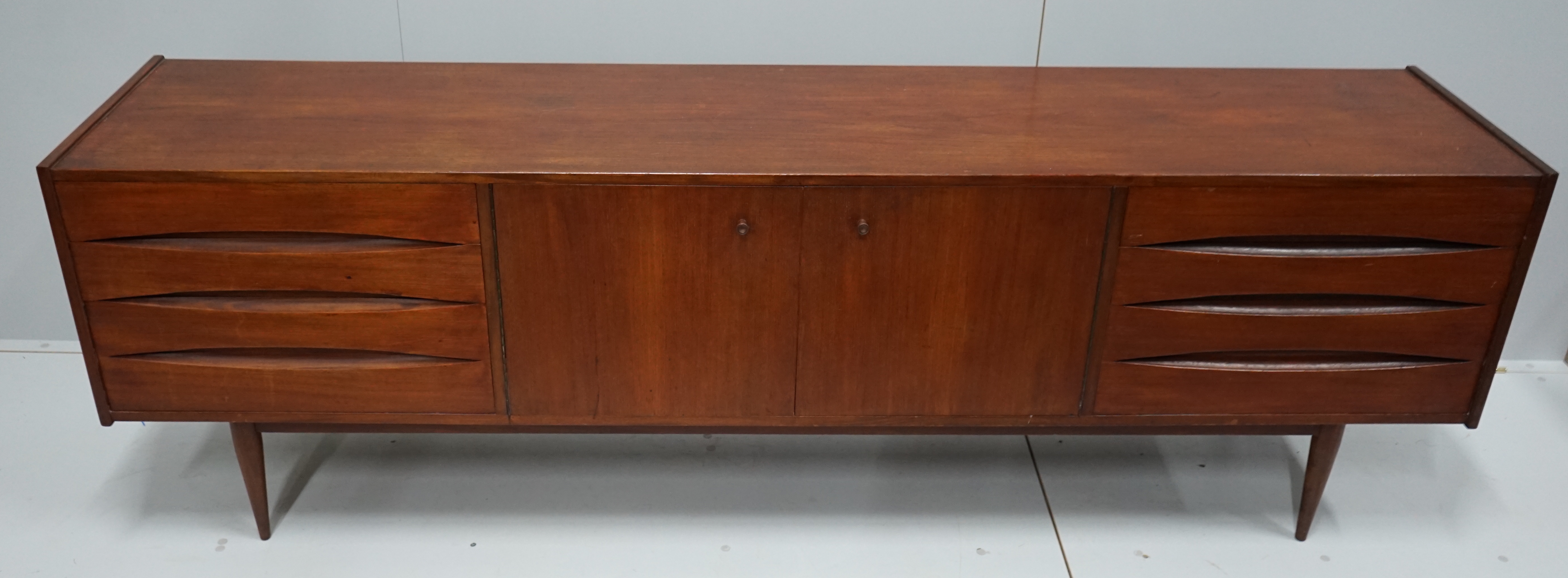 In the manner of Arne Vodder, a mid century teak sideboard width 221cm, depth 45cm, height 73cm.